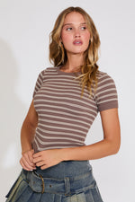 Woman wearing a brown and beige striped shirt with a white background