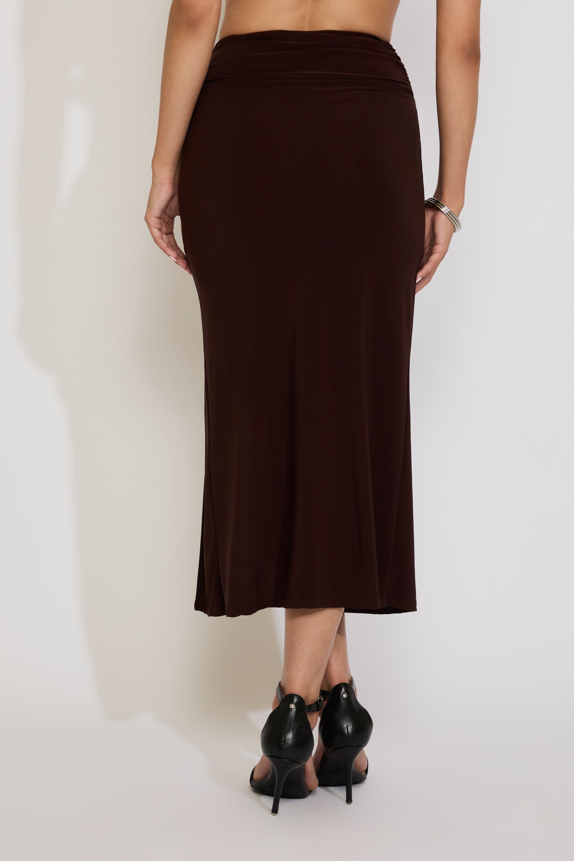 Brown skirt worn by a person on a white background