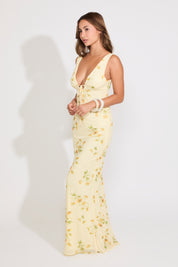 Model is wearing a light yellow floral v neck maxi dress on a white background.