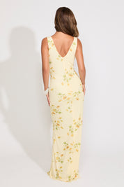 Model is wearing a light yellow floral v neck maxi dress on a white background.