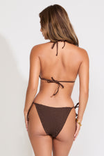 Woman wearing brown swimsuit on a white background