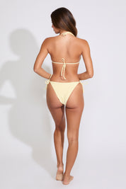 Model is wearing a solid yellow bikini set on a white background. 