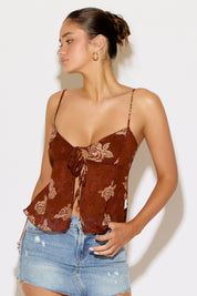 Woman wearing a brown top and denim skirt on a white background