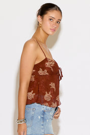 Woman wearing a brown top and denim skirt on a white background