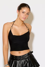 Woman wearing a black halter top and black leather skirt against a white background