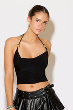 Woman wearing a black halter top and black leather skirt against a white background