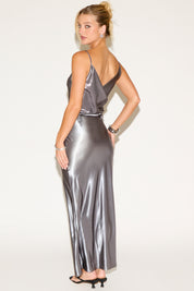 Woman wearing a silver metallic dress against a white background