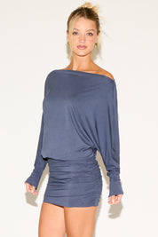 Woman wearing a blue off-shoulder dress on a white background