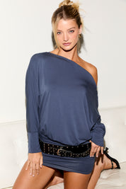 Woman wearing a blue one-shoulder dress with a belt on a white background