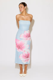 Woman wearing a strapless dress with floral design on a white background