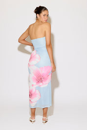 Woman wearing a strapless dress with pink floral pattern on a white background