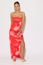 Woman wearing a strapless red floral dress on a white background