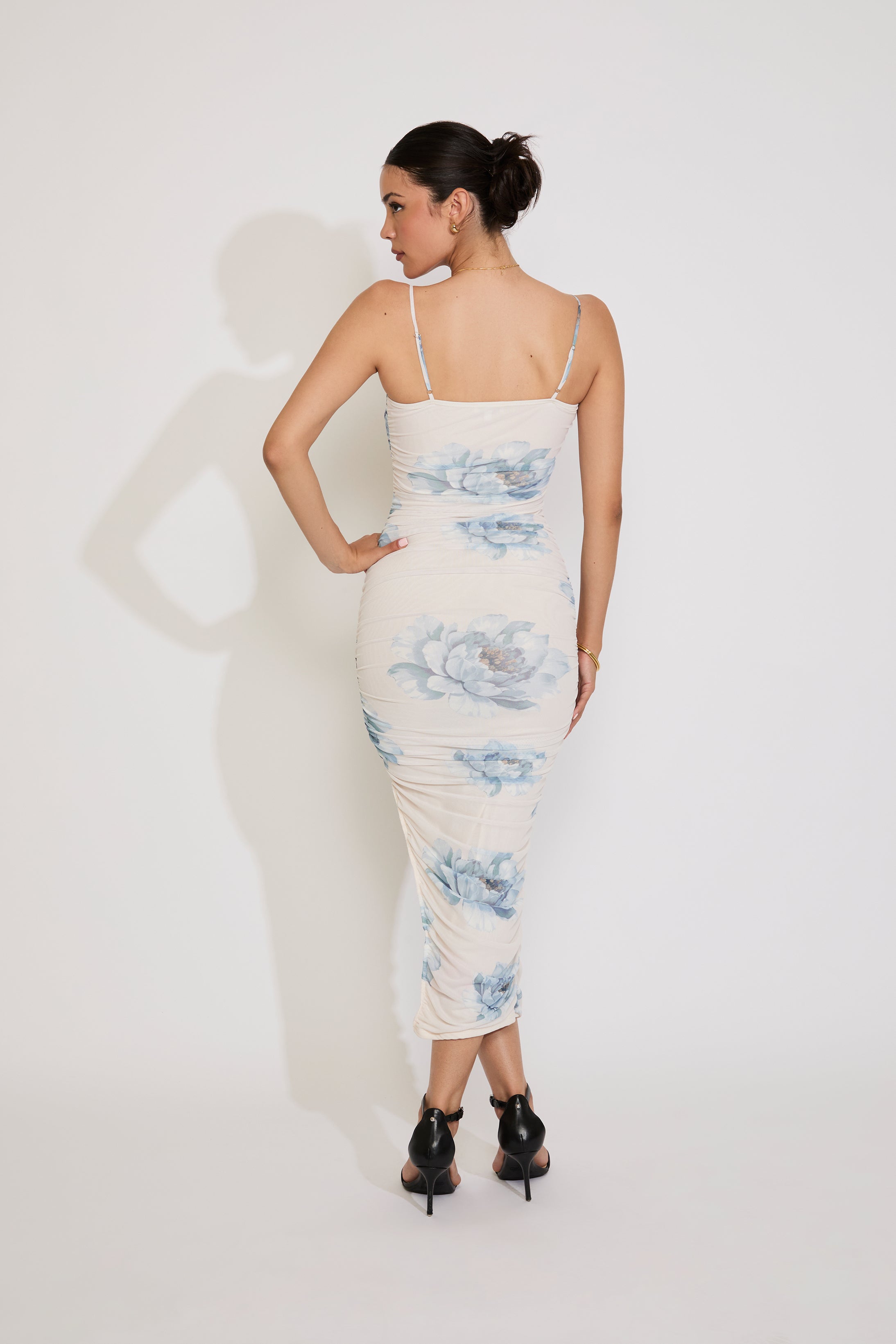 Woman wearing a floral dress against a white background