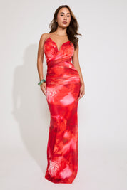 Model is wearing an abstract floral cross back ruched maxi dress on a white background.