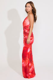 Model is wearing an abstract floral cross back ruched maxi dress on a white background.