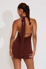 Woman wearing a brown halter dress with a white background