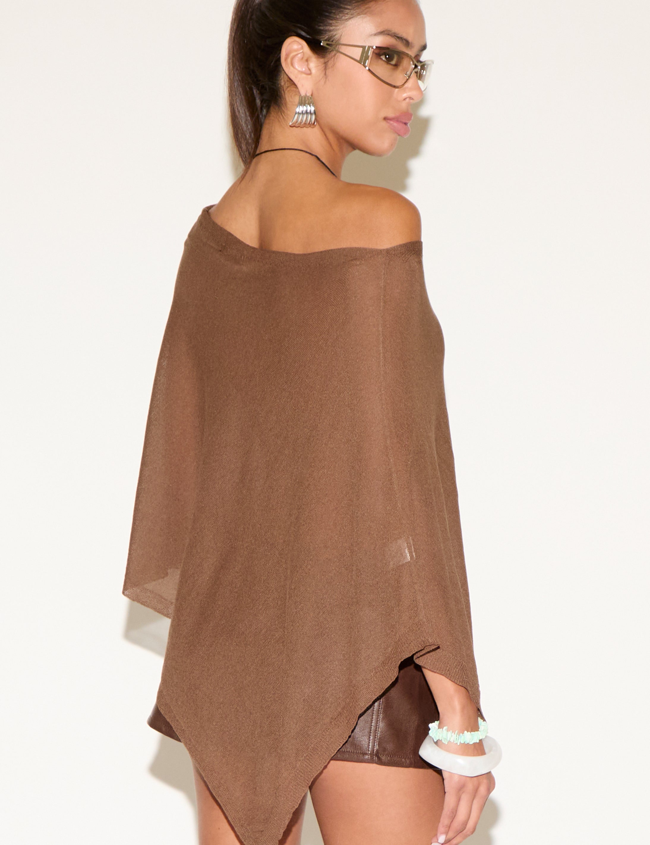 Woman wearing a brown off-shoulder top against a white background