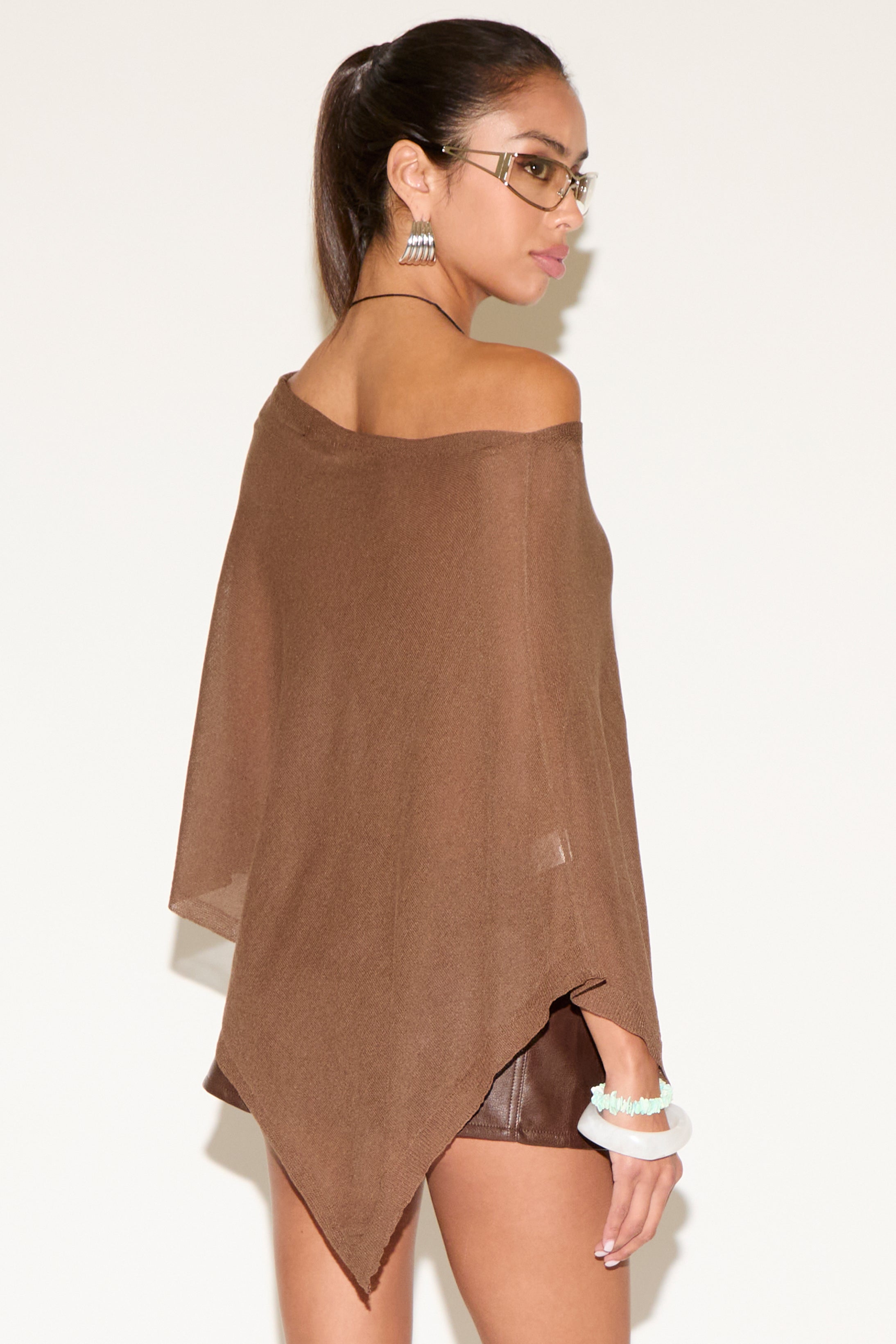 Woman wearing a brown off-shoulder top against a white background