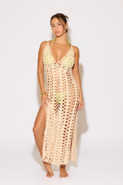 Woman wearing a beige crochet dress with a white background