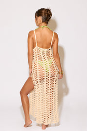 Woman wearing a beige crochet cover-up on a white background