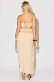 Model is wearing a natural crochet bandeau top and a matching crochet maxi skirt on a white background. 