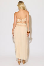 Model is wearing a natural crochet bandeau top and a matching crochet maxi skirt on a white background. 