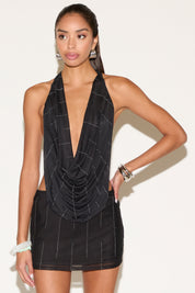 Woman wearing a black dress with a plunging neckline on a white background