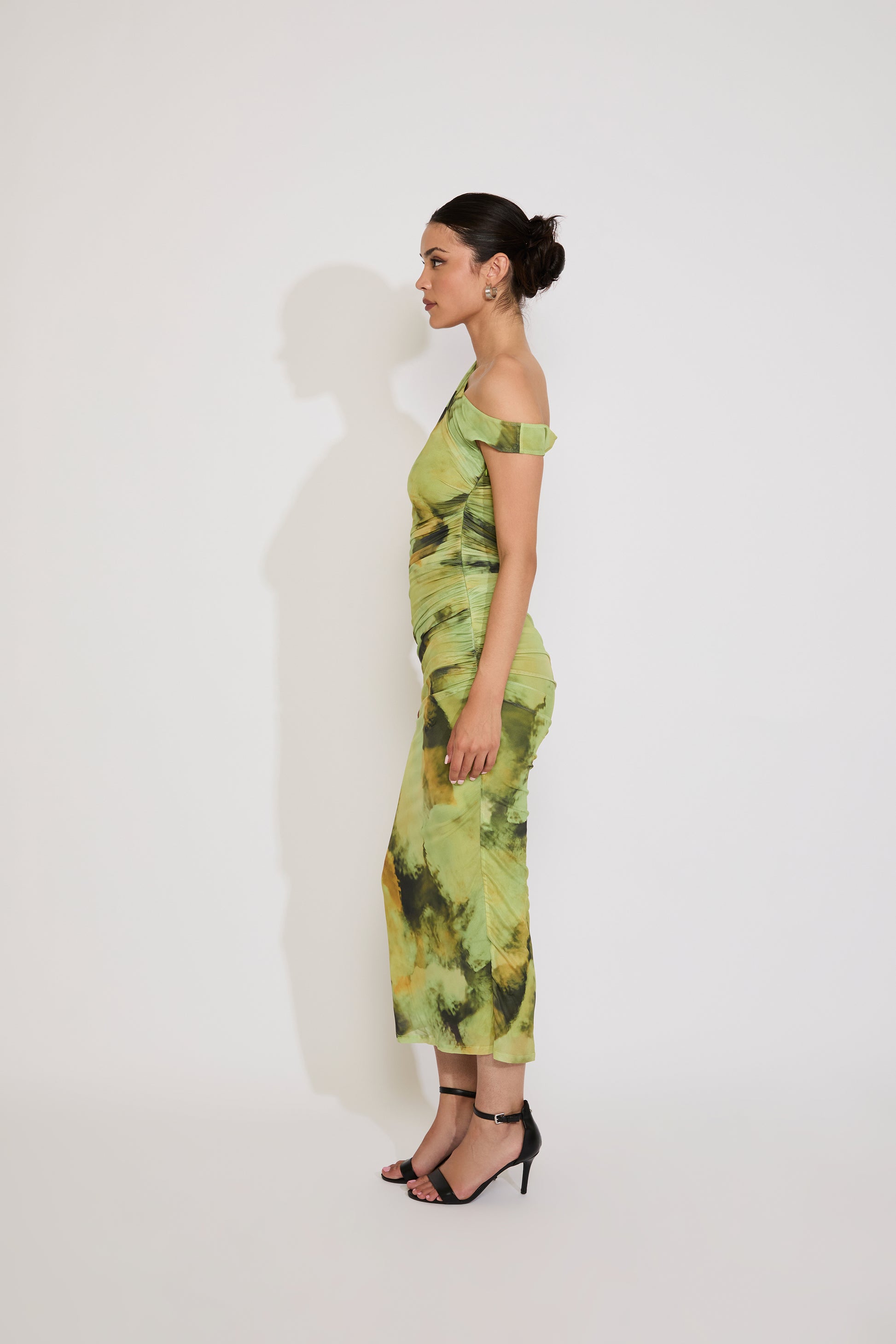 Woman wearing a green patterned dress against a white background