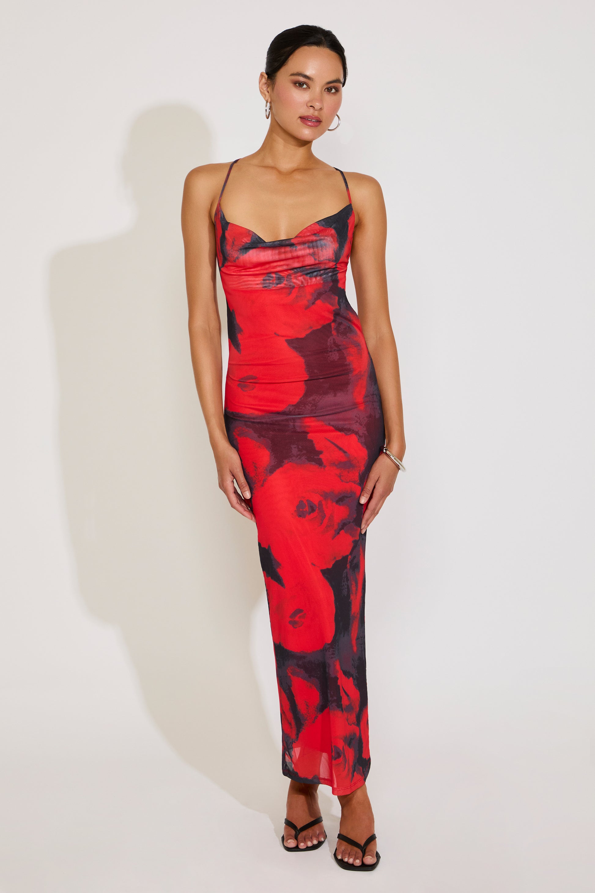 Woman wearing a red and black floral dress on a white background