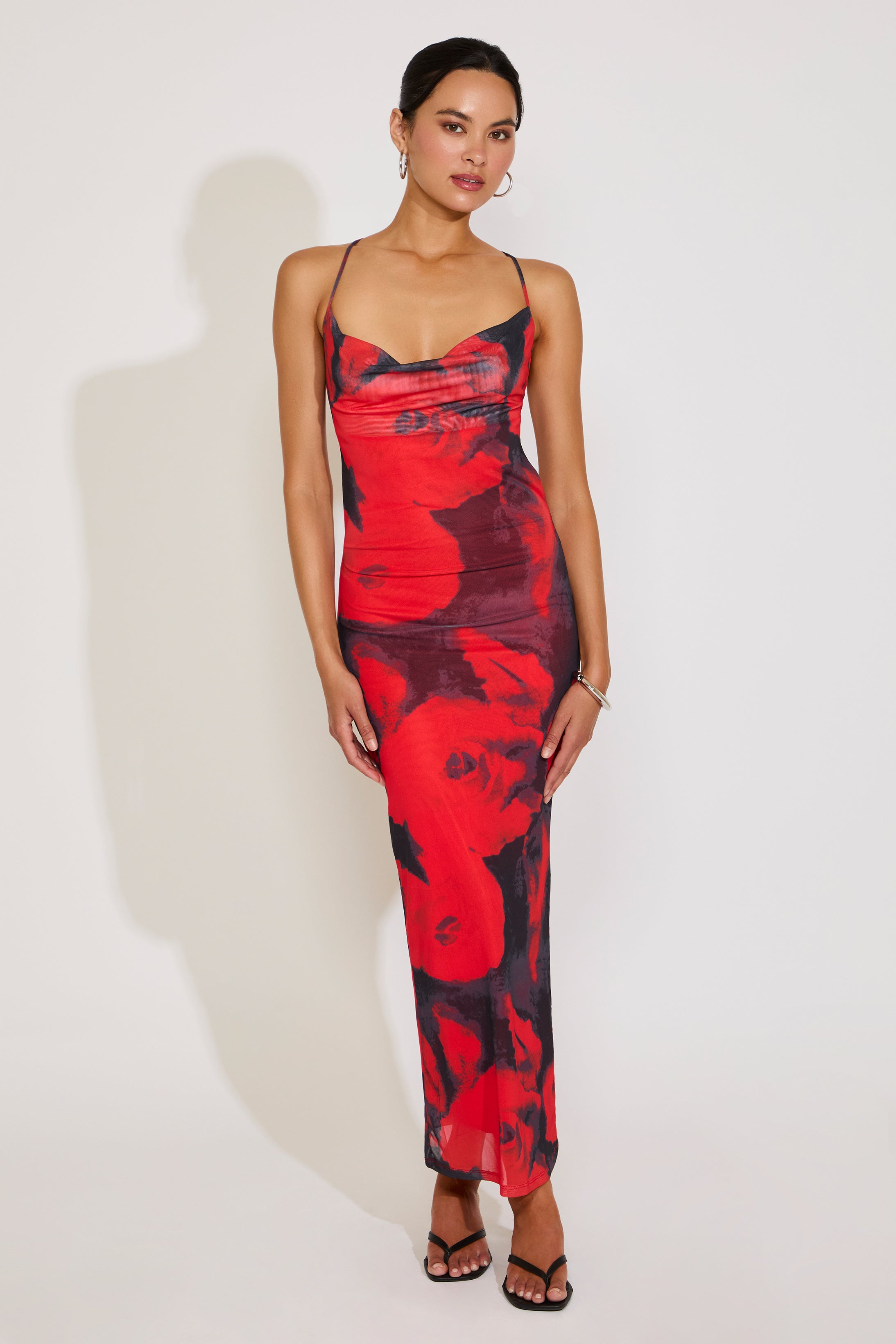 Woman wearing a red and black floral dress on a white background