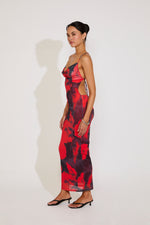 Woman wearing a red and black patterned dress against a white background