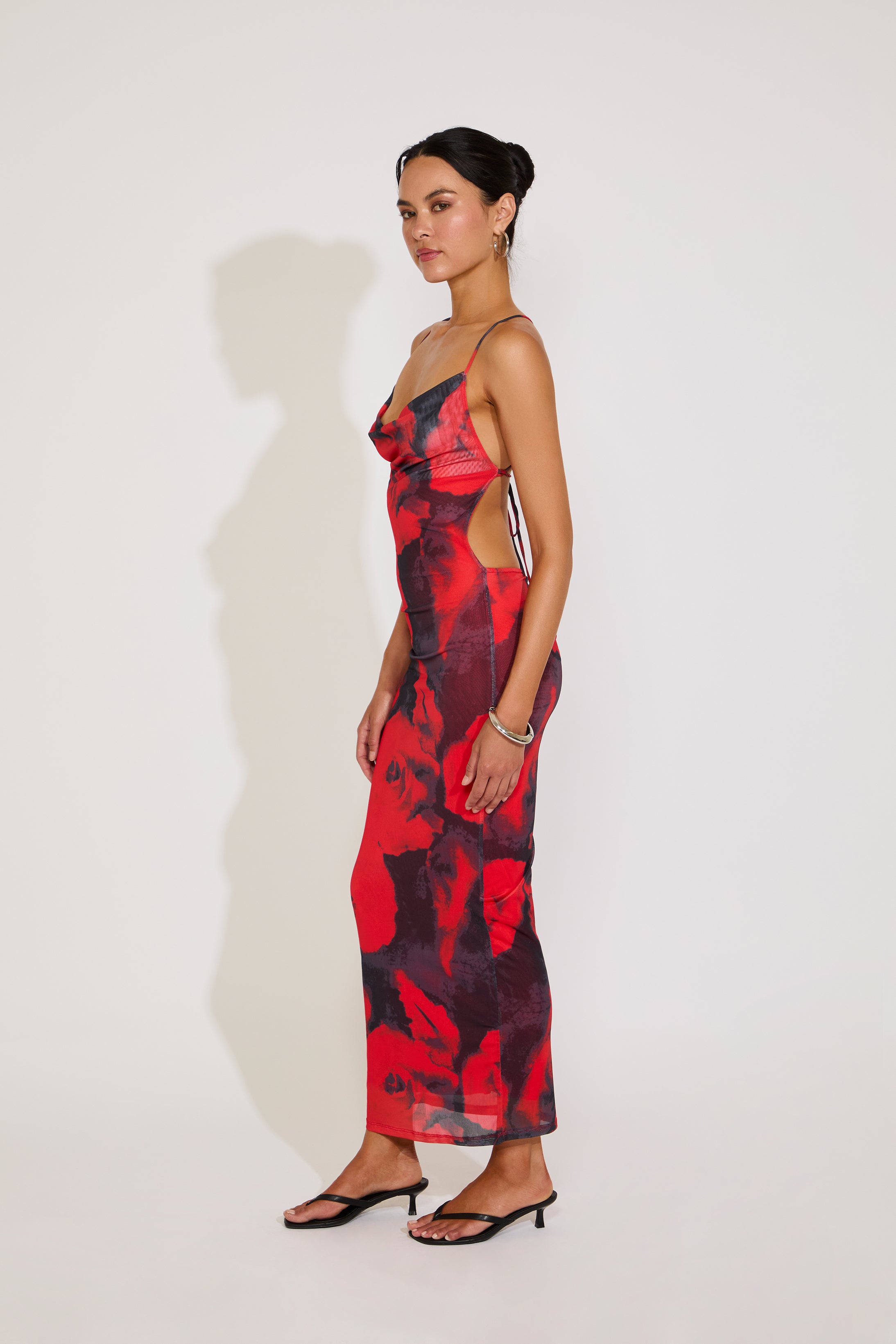 Woman wearing a red and black patterned dress against a white background