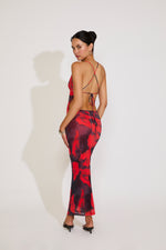 Woman wearing a red and black patterned dress on a white background