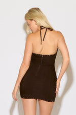 Model is wearing a brown halter neck, western design bodycon mini dress on a white background. 