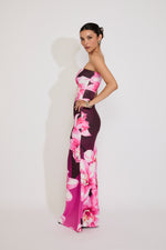 Woman wearing a strapless floral evening gown on a white background
