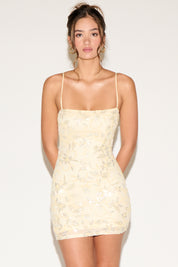 Woman wearing a light yellow dress against a white background