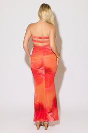 Model is wearing a orange strapless mesh printed ruched maxi dress on a white background.