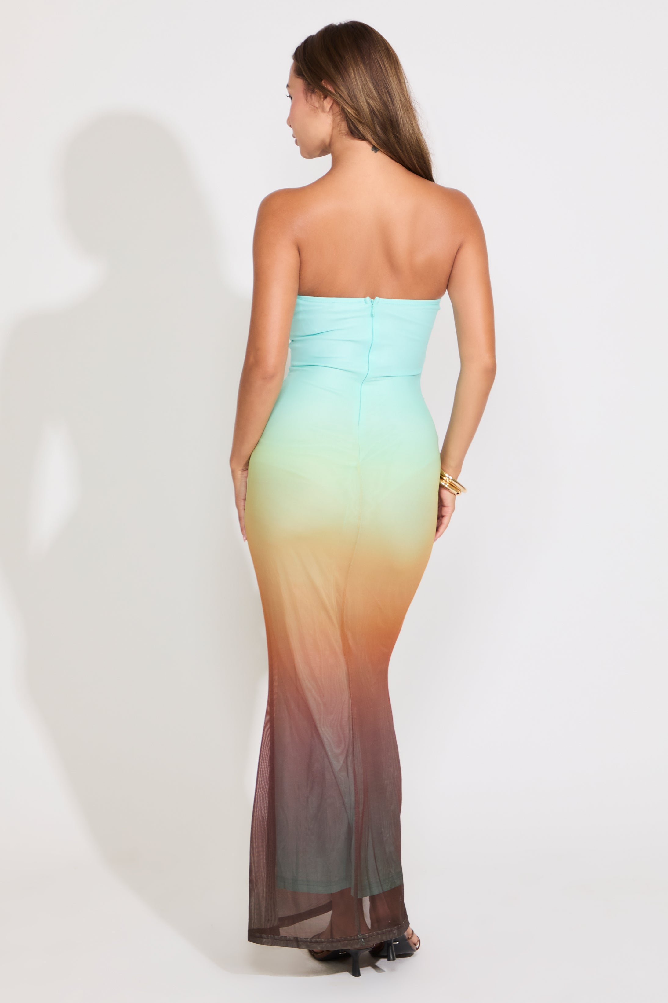 Model is wearing a strapless mermaid maxi dress on a white background.