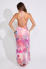 Model is wearing a pink FLORAL RUFFLE BEADED BACKLESS MAXI DRESS with pink heels on a white background.