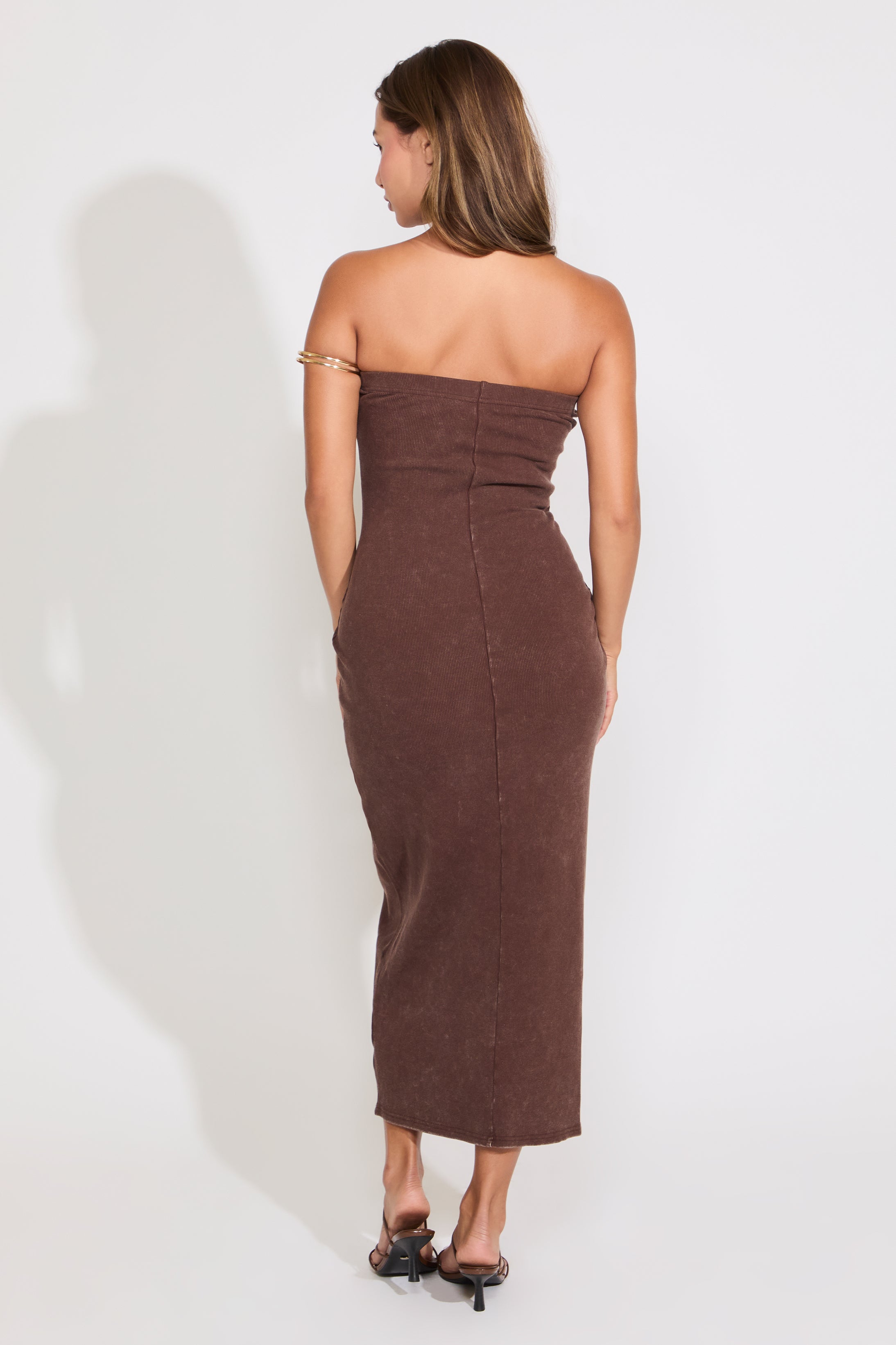 Model is wearing a chocolate acid washed ribbed midi tube dress on a white background.