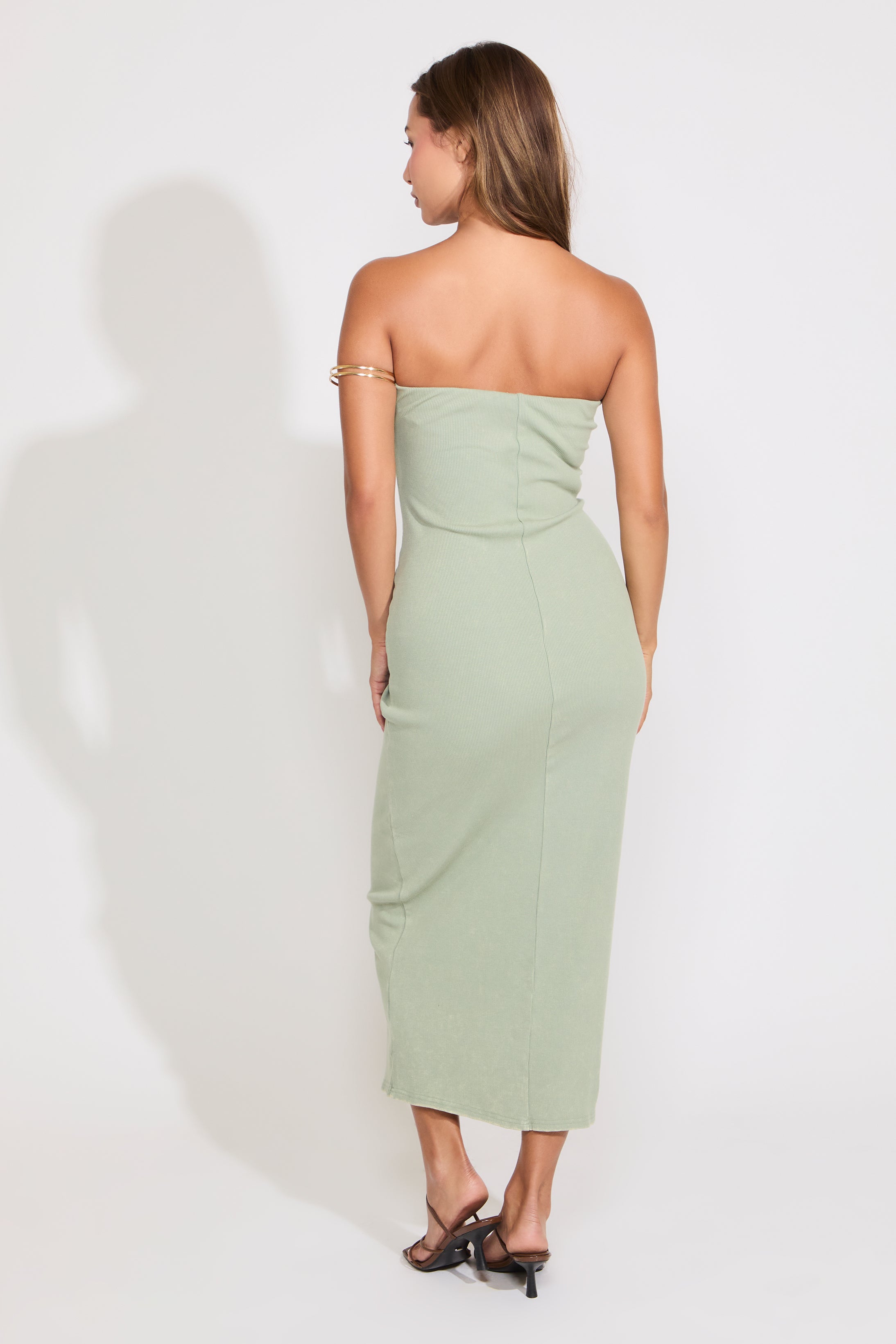 Model is wearing a sage acid washed ribbed midi tube dress on a white background.