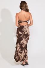 Model is wearing a strapless brown floral print maxi dress on a white background.