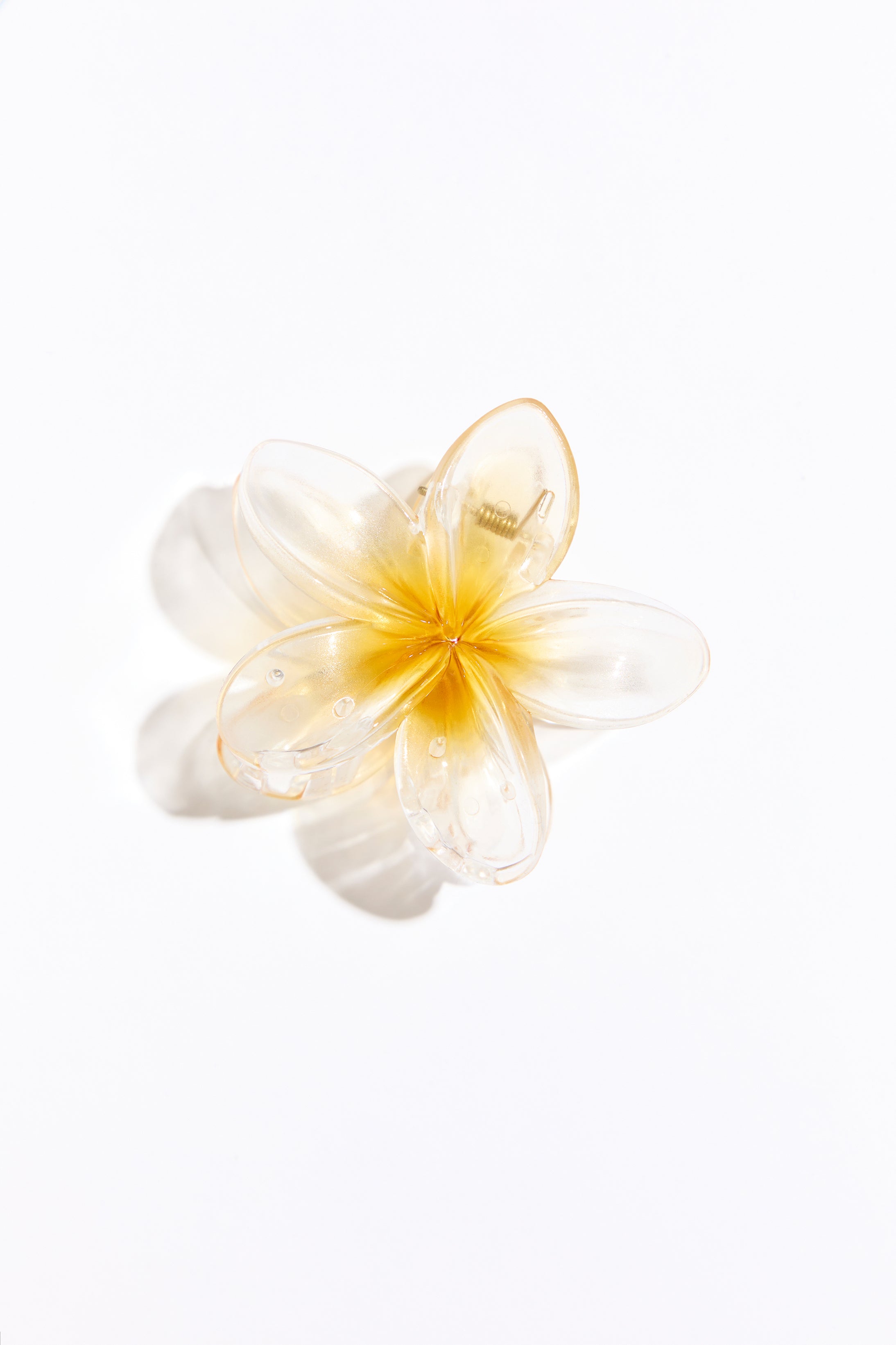 Yellow plastic hair clip on a white background. 