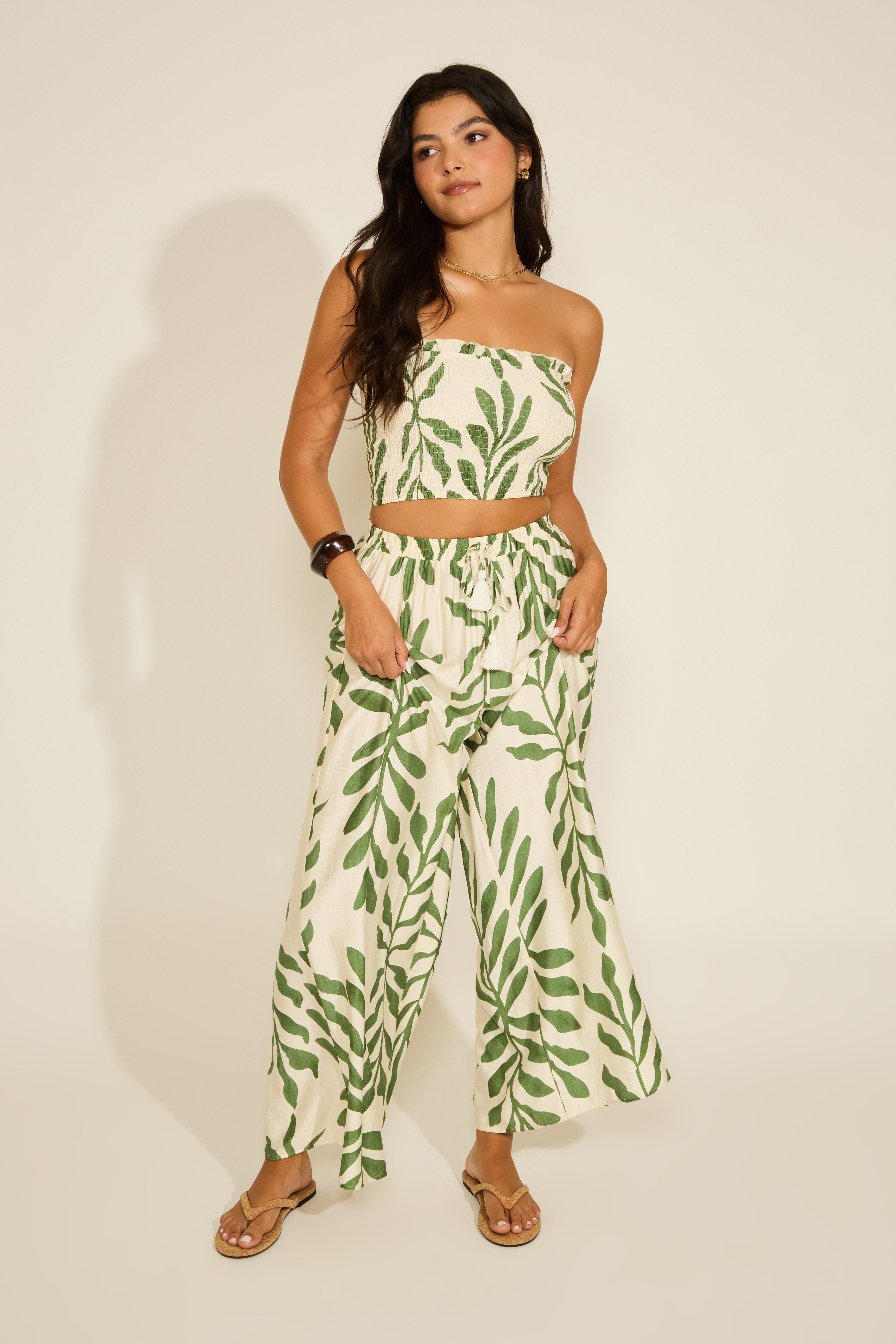 Woman wearing a green leaf-patterned outfit on a plain background