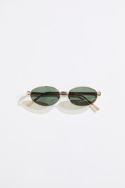 Gold rimmed glasses with olive lenses on a  white background