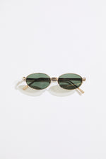 Gold rimmed glasses with olive lenses on a  white background