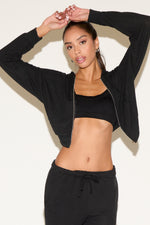Woman wearing a black athletic outfit against a white background