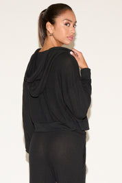 Woman wearing a black outfit against a plain background