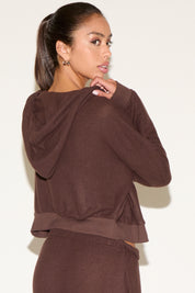 Woman wearing a brown outfit against a white background