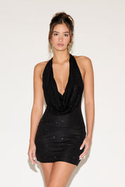 Woman wearing a black dress with a plunging neckline on a white background